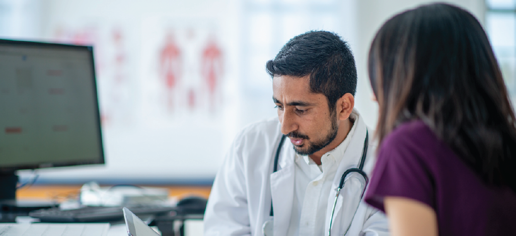 Following Patient Bill of Rights - Male doctor using a tablet device to discuss treatment options with his female patient.