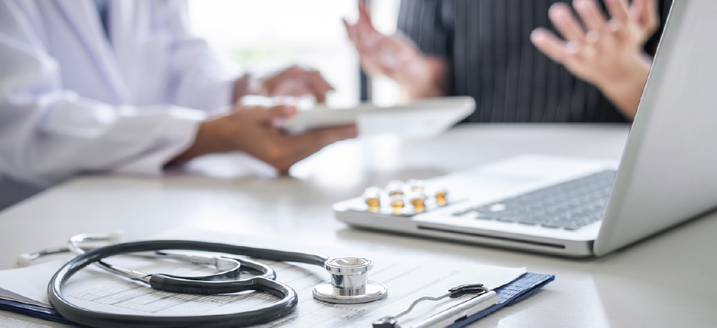 Doctor speaking with an auditor during an external audit - avoiding medical upcoding and downcoding.