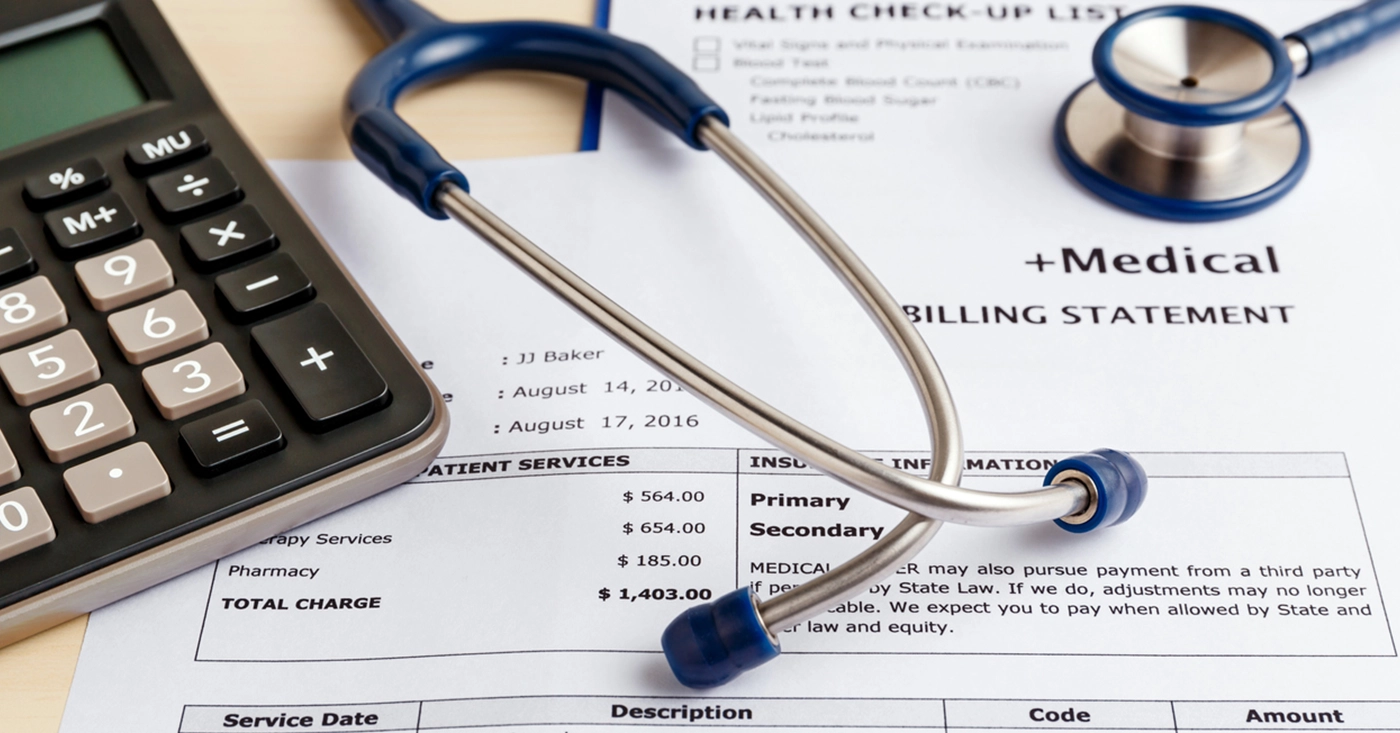 Patient’s billing statement along with a doctor’s stethoscope and calculator - medical billing for small practices.