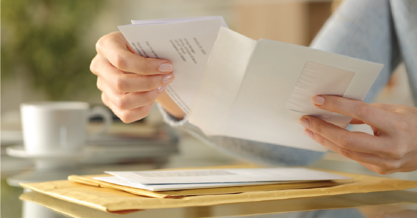 Woman opening a mailed billing statement - sending billing reminders to patients.