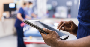 Relative value units evolving to value-based care - Male doctor using a digital tablet to assess patients in an emergency room.