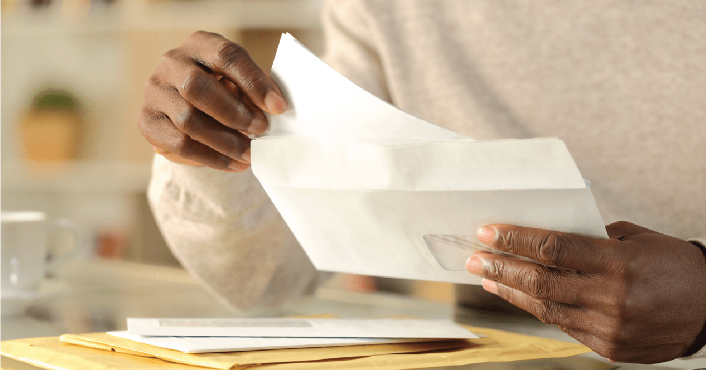 Man opening an envelope containing medical bills - patient payment plans concept.