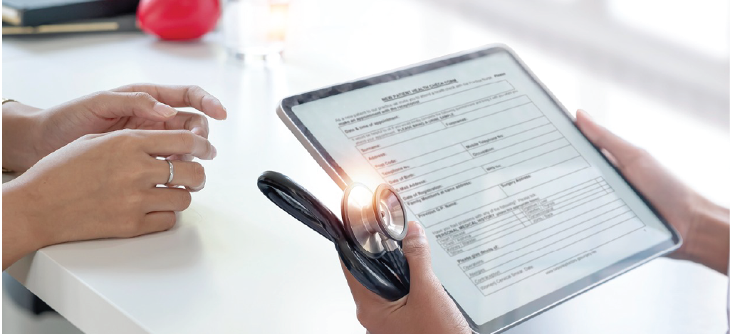 Doctor holding a digital tablet while reviewing a patient’s medical record by using an EMR system.