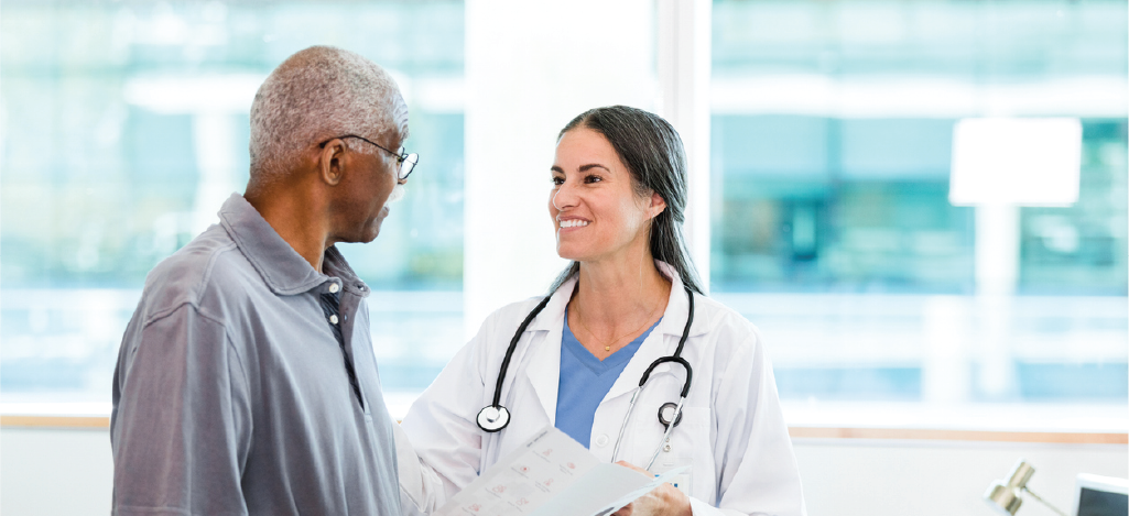 Practicing patient-centric billing - Female doctor speaking to her male patient regarding medical billing.
