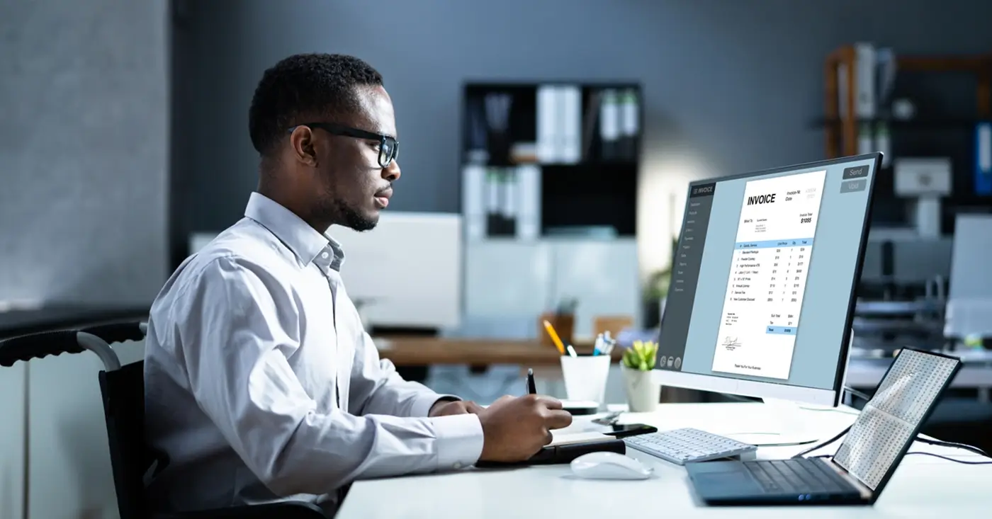 A businessman checking his computer for online bill pay options.