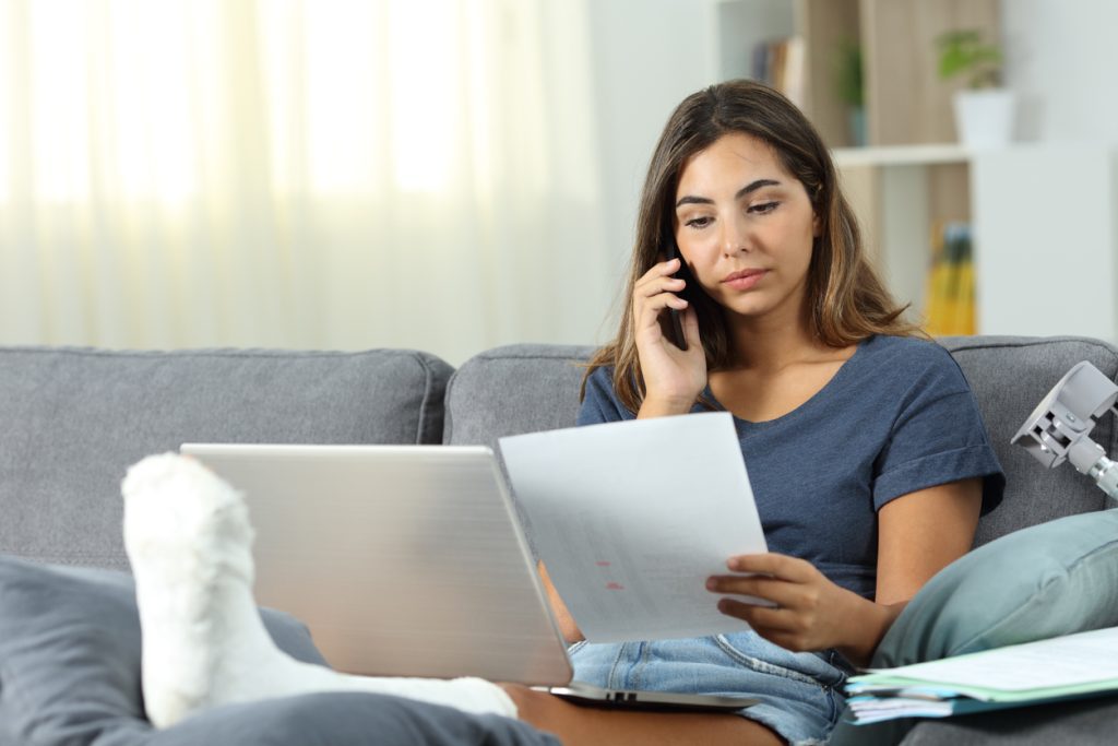 A woman with a broken leg calls her medical office to make a payment since they don't have online bill pay options. 