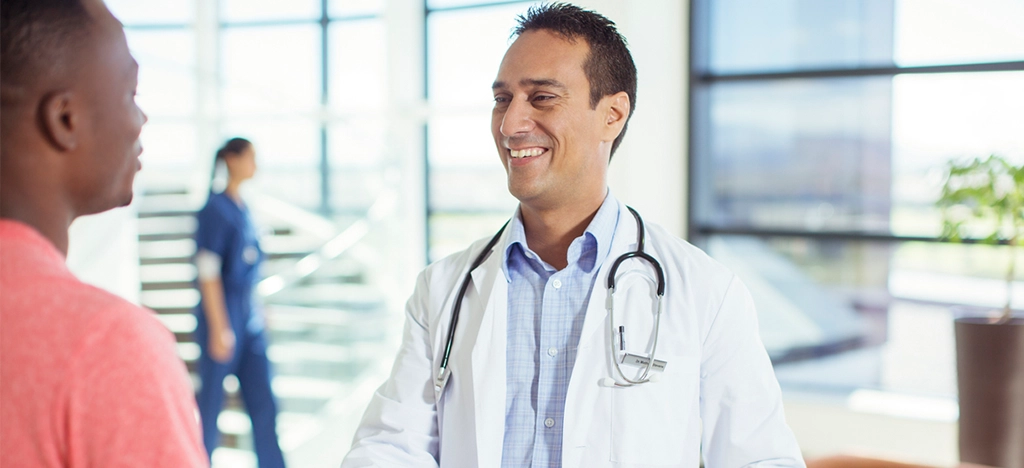 Doctor shaking hands with his patient during a consultation - building patient loyalty concept.
