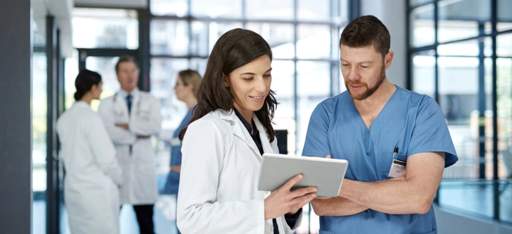 Medical billing software for small practices - Two doctors looking at their medical billing software using a tablet device.