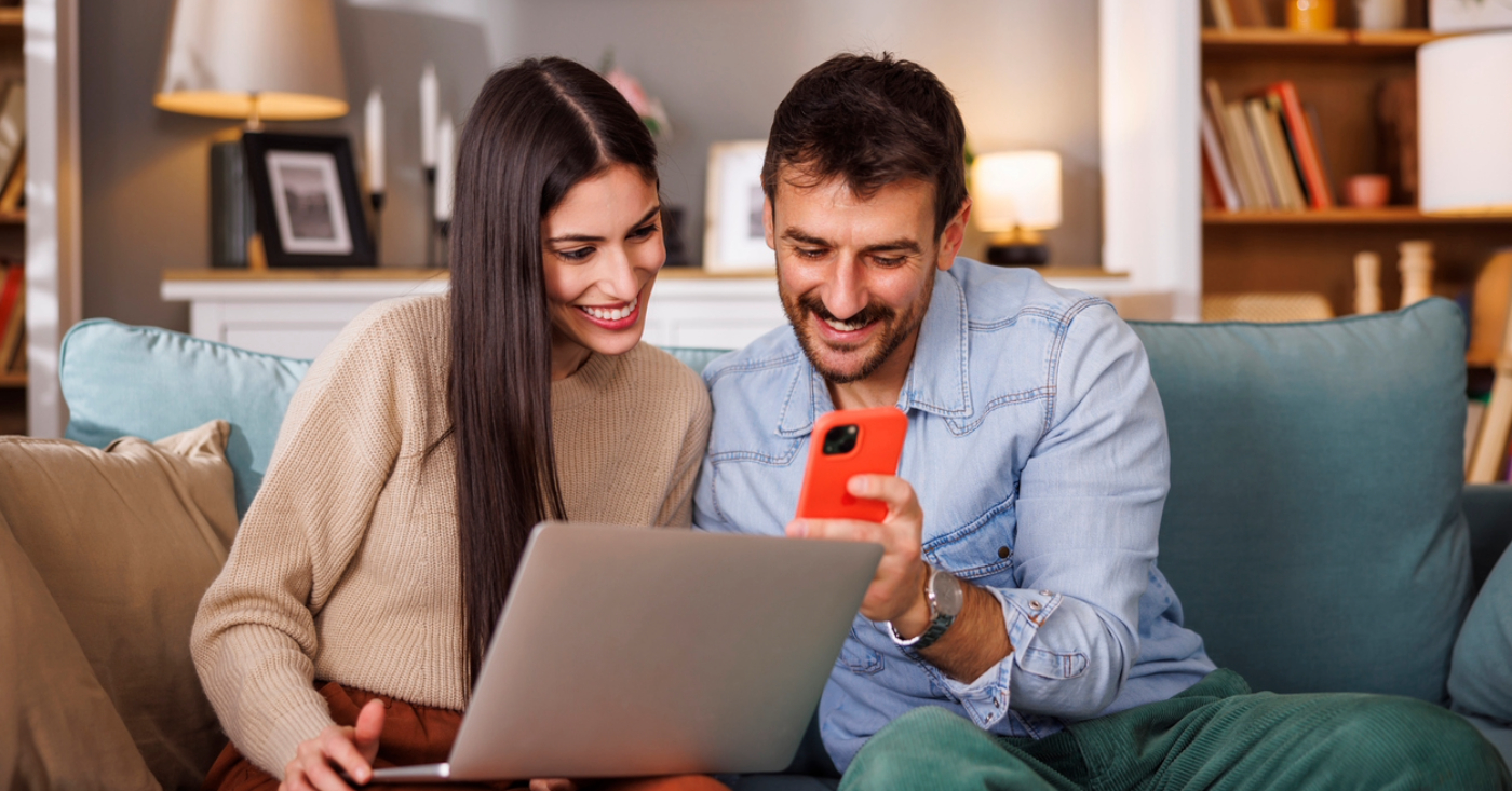 Payment reminder process - A couple at home using a smartphone and a laptop to view and check their medical bill.