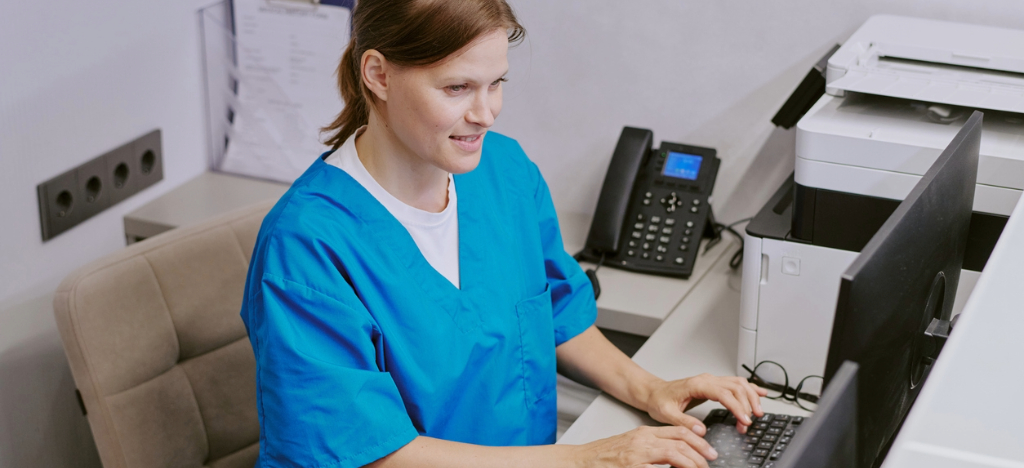 Payment strategies - A medical staff member using a computer to send automated payment reminders to patients.