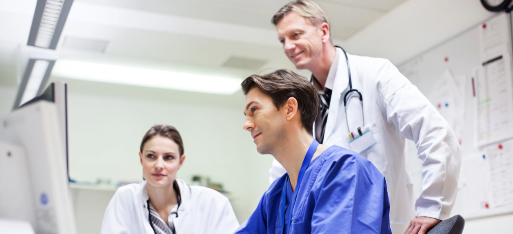Merchant accounts for practices - A group of doctors looking at patient statements on a computer screen.
