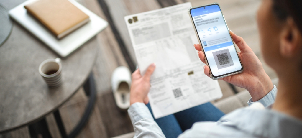 QR codes for mailed statements - A woman using a smartphone to scan a QR code printed on her medical bill.