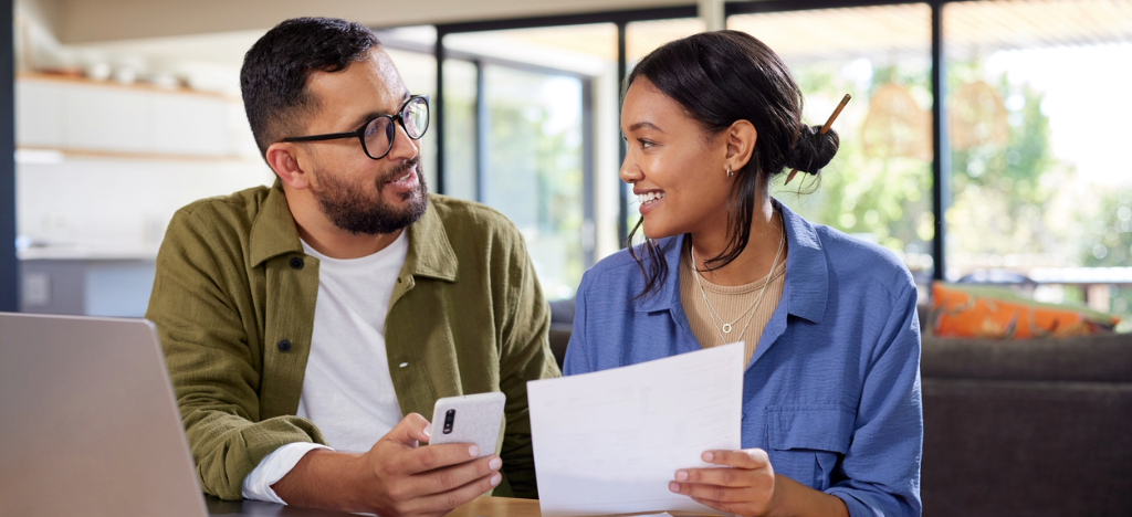 Paper and electronic billing - A couple at home reviewing and paying their medical bills online.