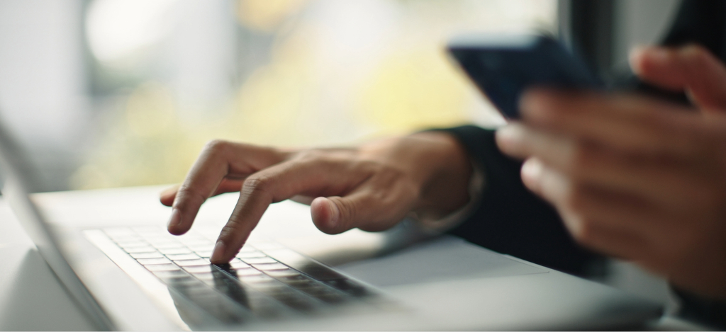 HIPAA-compliant text messaging - A man using his laptop and smartphone to check for his online medical bill.