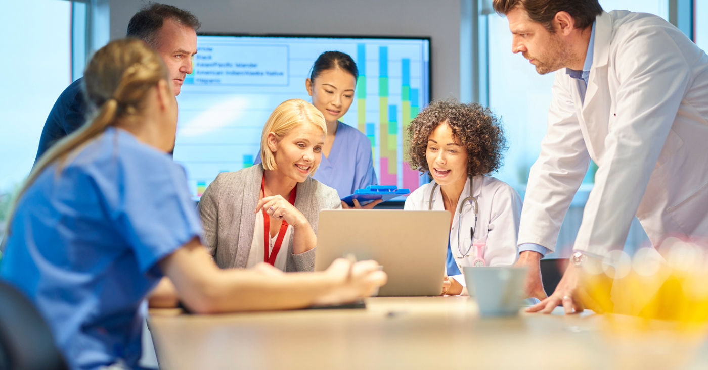 Medical billing practices - A group of medical professionals discussing their practice’s revenue during a meeting.