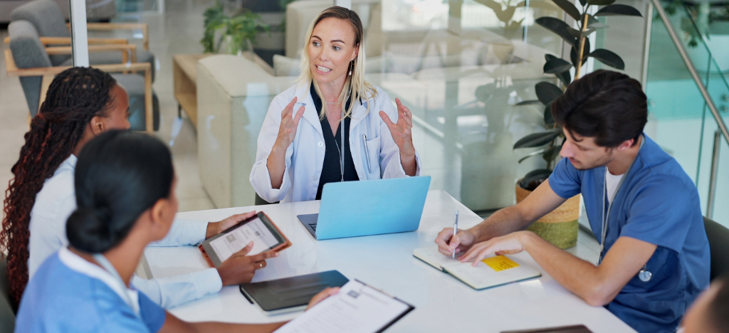 Outsourcing medical billing - A team of medical professionals having a meeting about staff workflows.