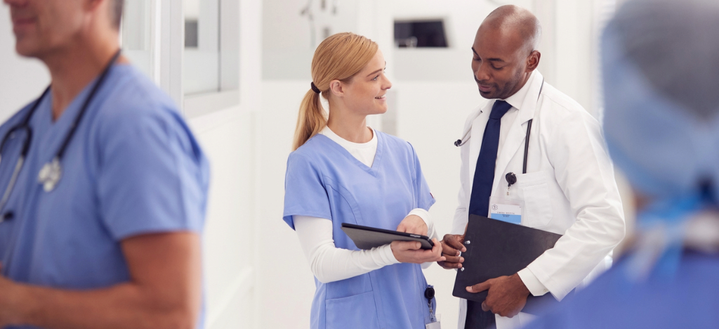 Electronic Bill Presentment and Payment - A female nurse using a tablet device to show a patient’s bill to a male doctor.