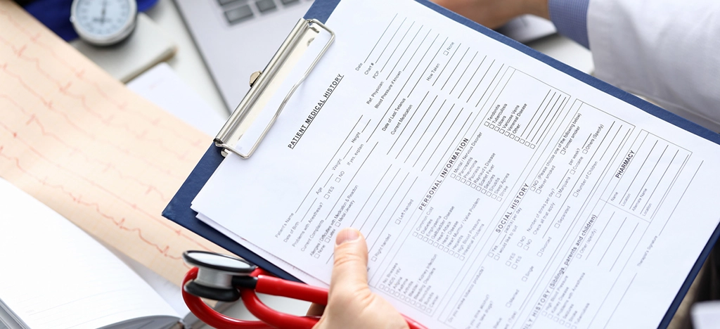 Accurate medical insurance billing - Female doctor taking her male patient’s insurance information.