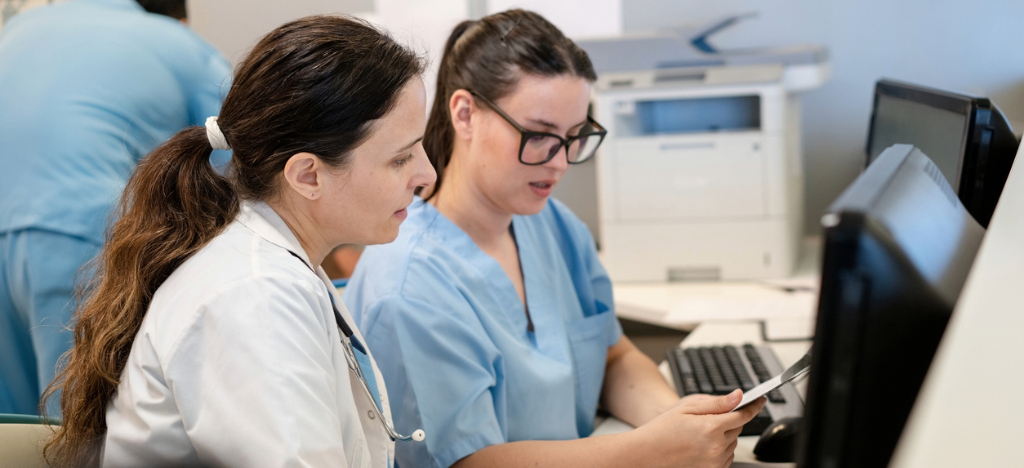 Medical billing systems - Two medical staff members checking a printed patient data.