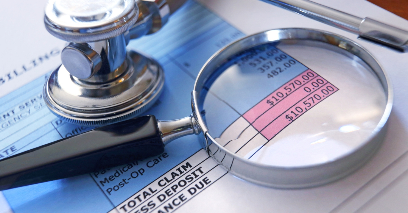 Price transparency in healthcare - A magnifying glass and stethoscope on top of a patient’s medical bill.