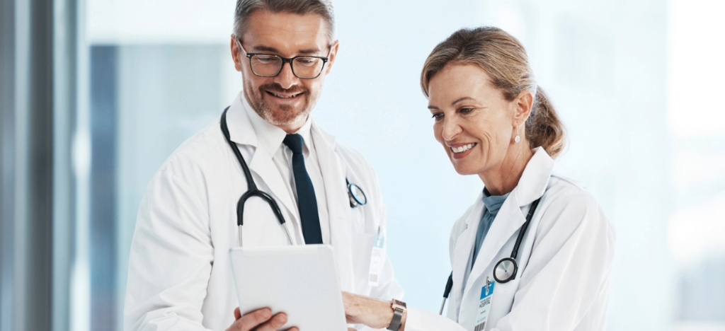 Improving revenue cycle metrics - Two doctors looking at their practice’s performance reports using a tablet device.