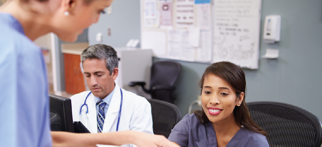 Female nurses discussing patient billing at work - preventing costly claim errors.