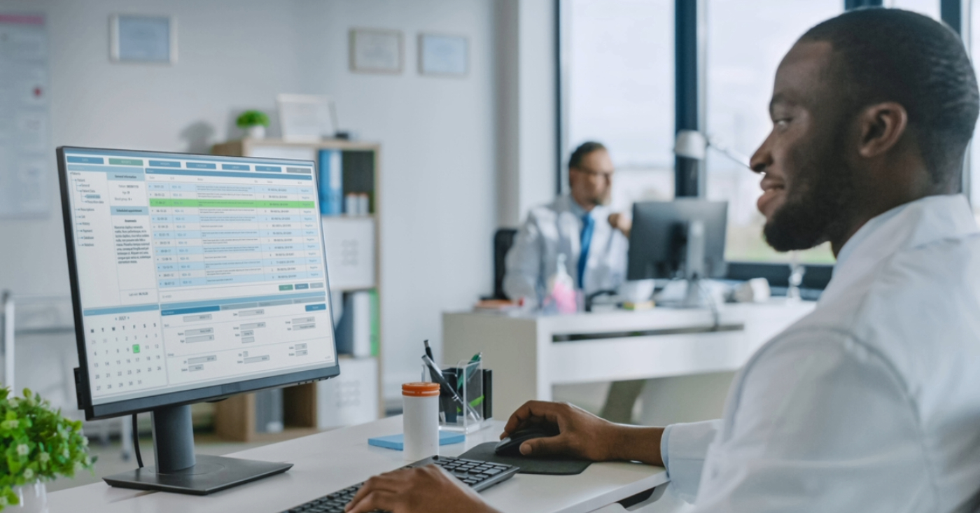 Medical billing software systems - A male doctor using a computer to access his practice’s medical billing software.