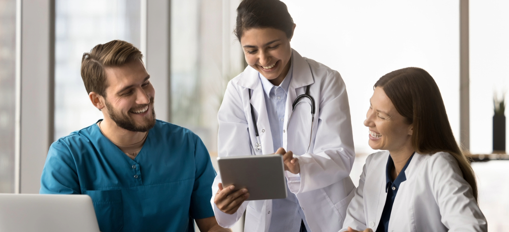 Payment reminder process - A team of medical professionals using a laptop and a tablet device to check their practice’s billing platform.