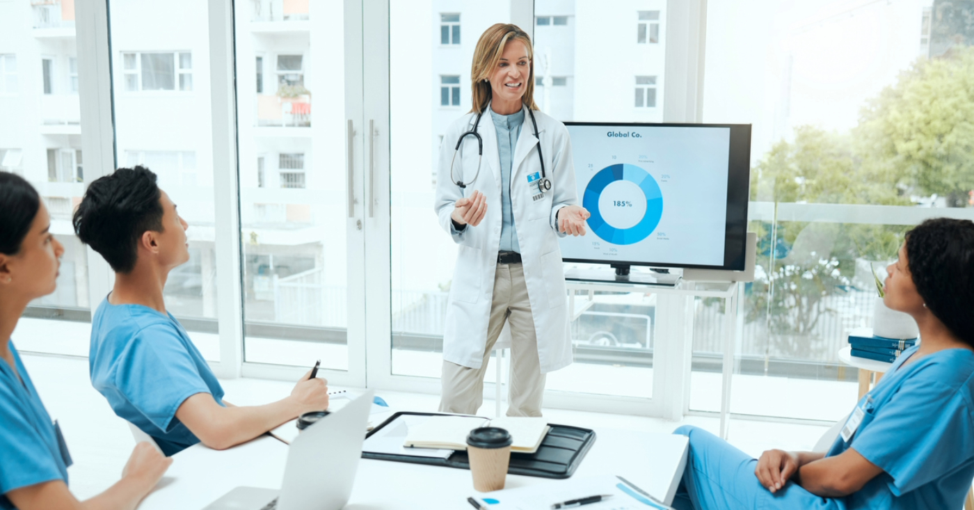 What is RCM - A female doctor discussing revenue cycle management with her colleagues during a meeting.
