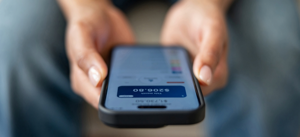 Modernizing payment reminder process - A woman holding a smartphone displaying her monthly hospital bill.