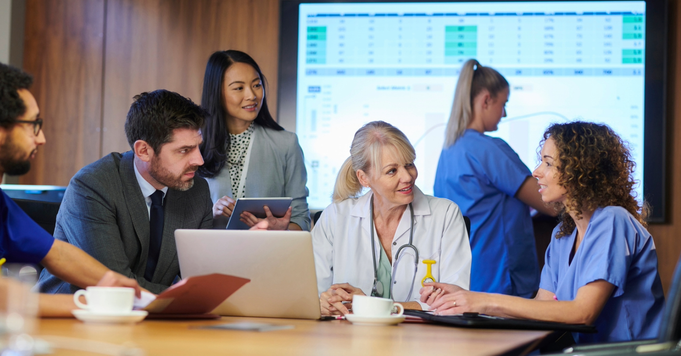 Preparing your billing strategy - A group of medical professionals and billing providers discussing hospital operations in a conference room.