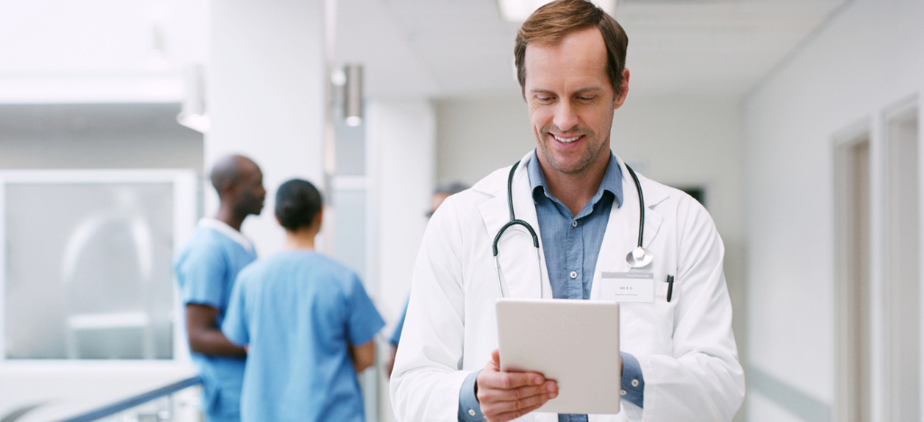 Medical billing checklist - A male doctor using a tablet device to review patient appointments.