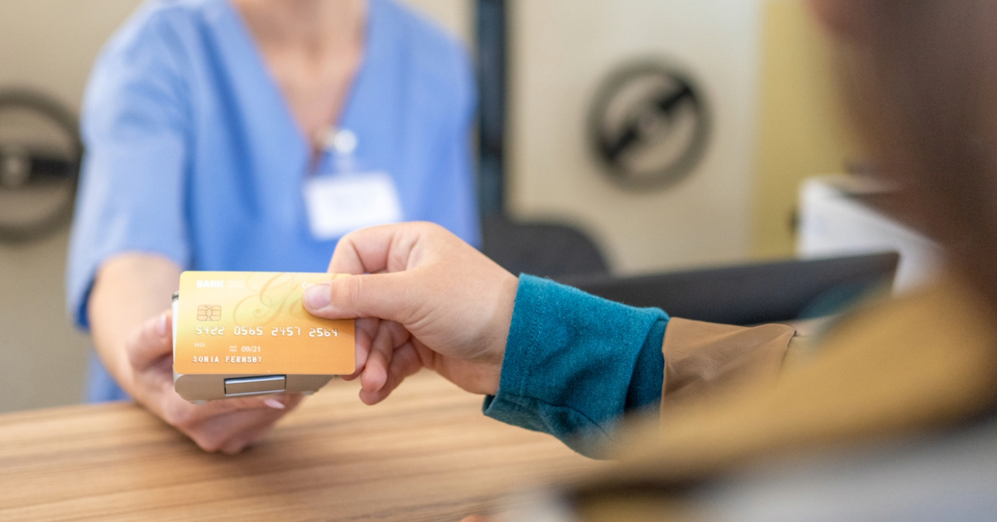 Benefits of merchant accounts - A female patient scanning her credit card with a hospital’s EMV reader.