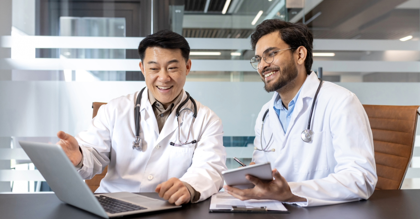Payment strategies - Two male doctors checking a medical billing software using a laptop.