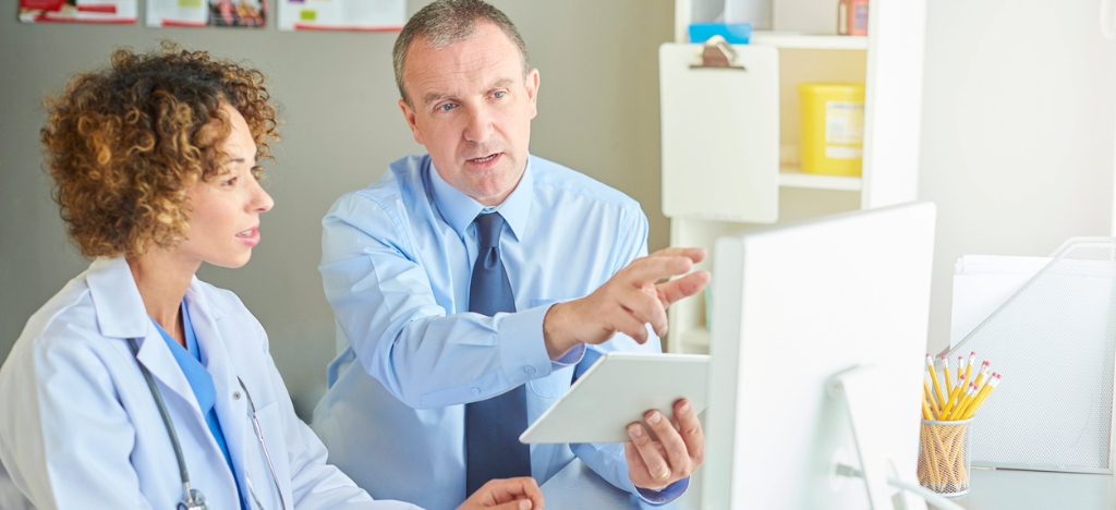 Billing software for medical practices - A billing software expert training a female doctor.