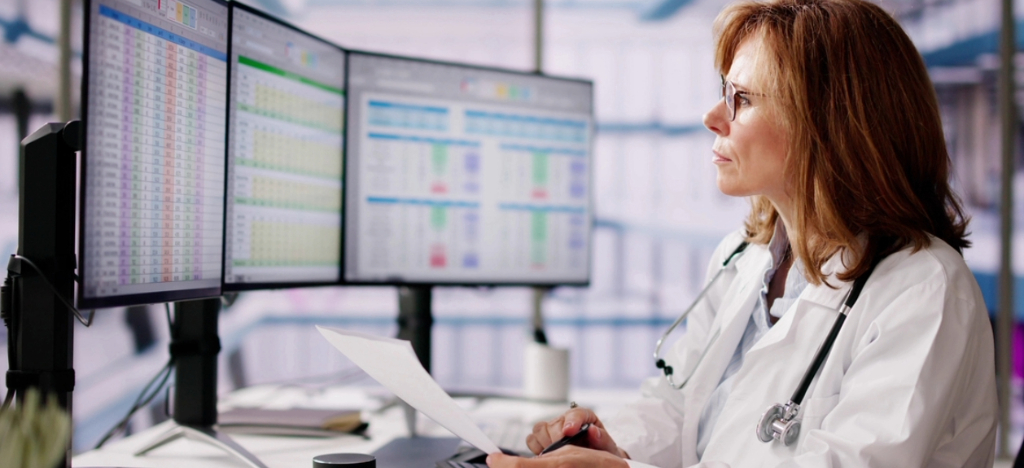 Medical billing software for small practices - A female doctor reviewing the practice’s revenue using a computer.