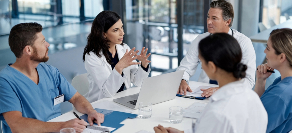 Medical billing best practices - A team of doctors in a conference room discussing their practice’s billing process.