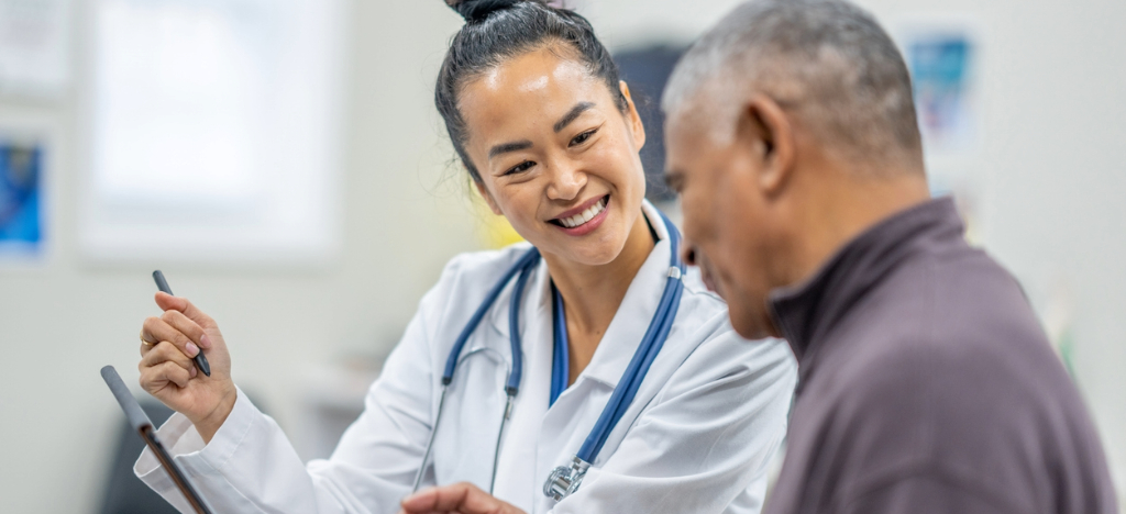 Medical billing software systems - A female doctor explaining payment plans to her senior male patient.