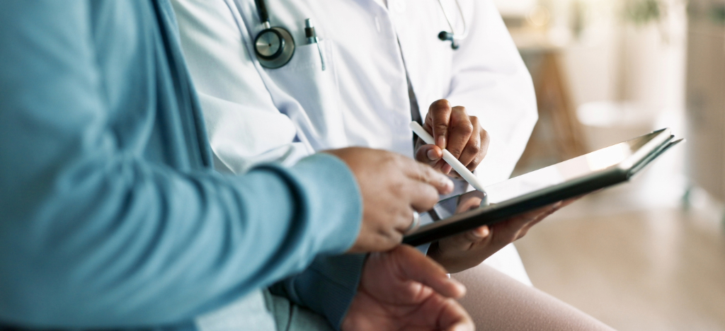Patient payment plan - A doctor holding a tablet device while explaining a patient’s medical bill.