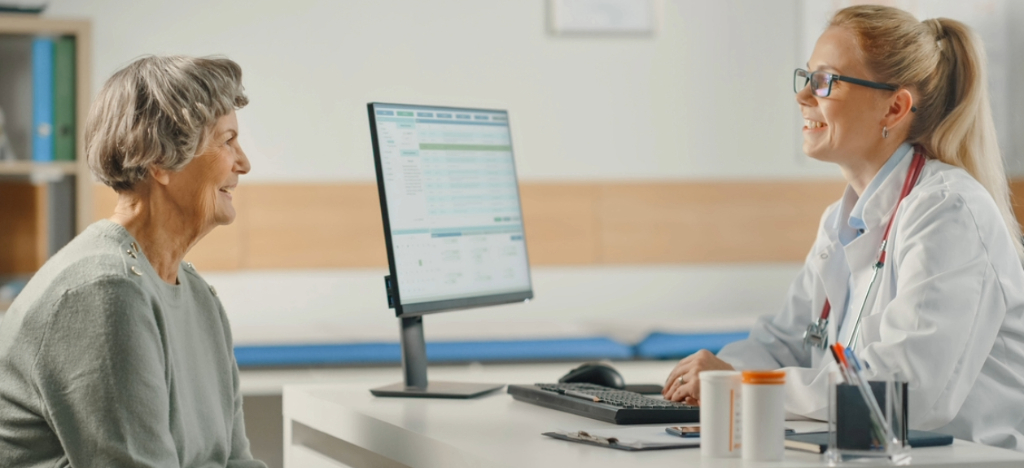 Reviewing revenue cycle metrics - A female doctor assisting a female senior patient during a medical consultation.