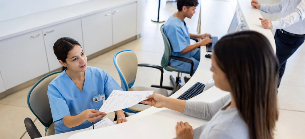 Improving in-office payments - A female hospital employee helping a female patient pay her bill.