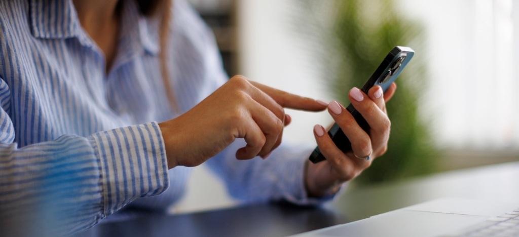 Managing patient surge - A woman at home using a smartphone to view her medical bill.