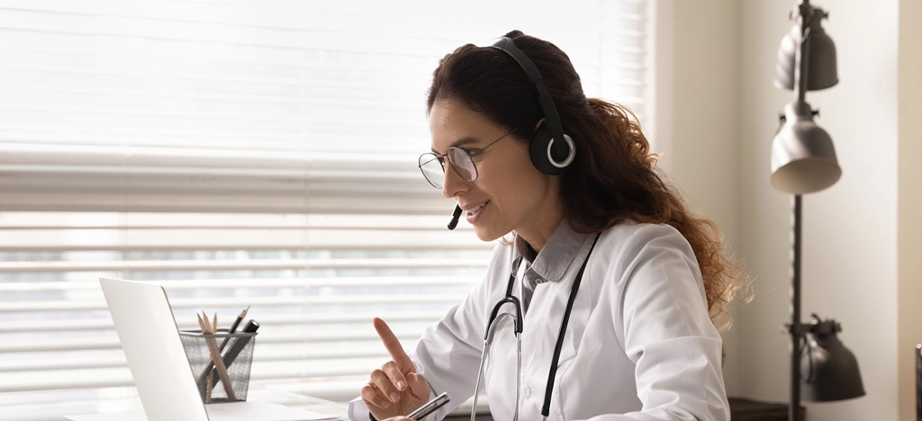 Female doctor using a laptop while on a video call with her patient.