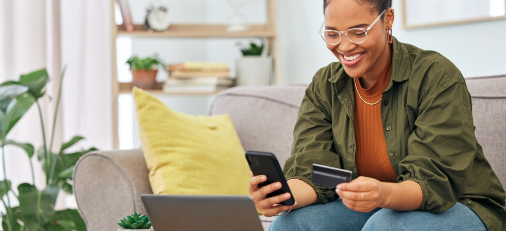 Electronic billing benefits - A woman at home paying her medical bills online using her smartphone.