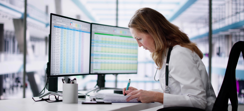 Medical debt collection rules - A female doctor reviewing patient payments and hospital revenue shown on a computer.