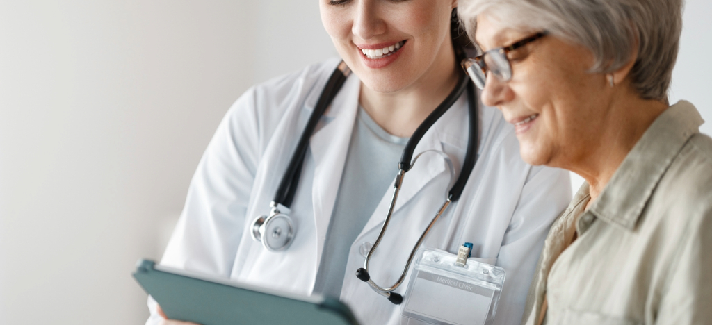 A female doctor using a tablet device to show payment plans to her senior patient.