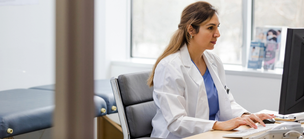 Strategies for infusion centers - A female doctor using a computer to access her practice’s medical billing software.