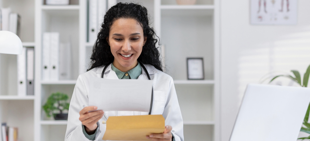 Utilizing mailed paper statement - A female doctor reviewing a printed patient bill.